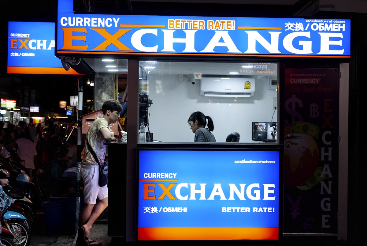 Man standing at a currency exchange counter abroad