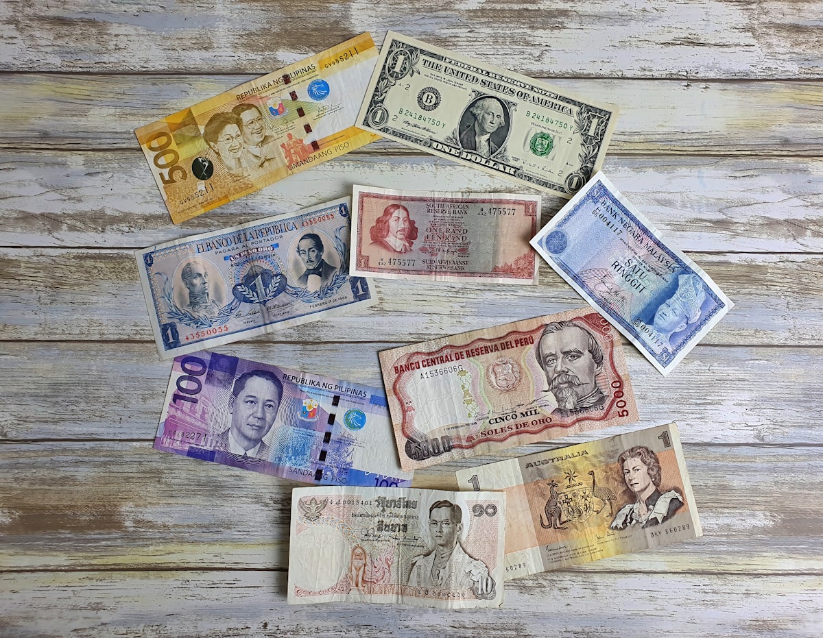 Different currencies from around the world spread on a wooden table
